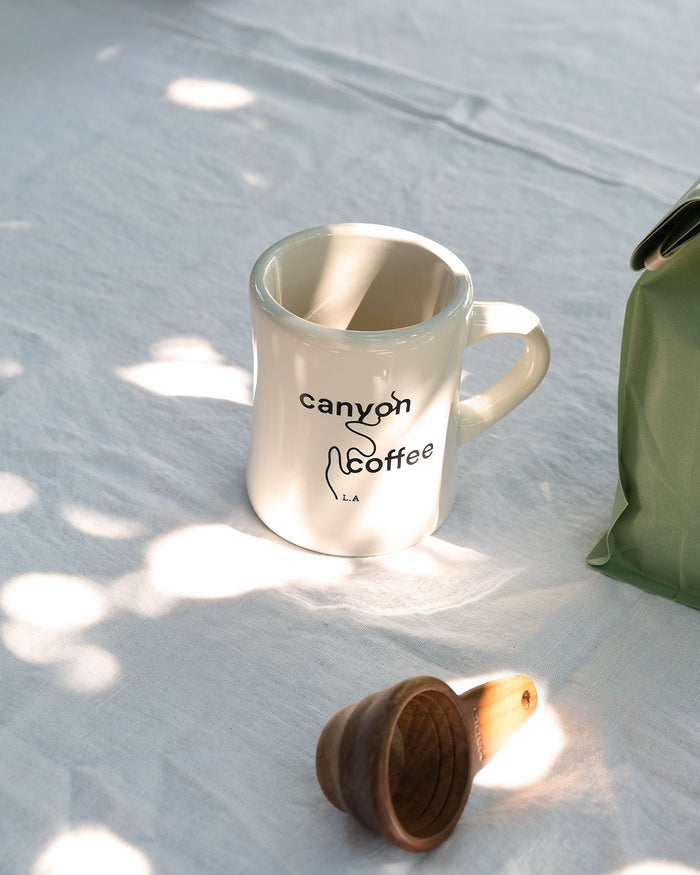 A diner mug with the Canyon Coffee logo on it