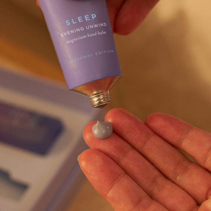 Tropic Sleep Evening Unwind magnesium hand balm being squeezed onto a hand.